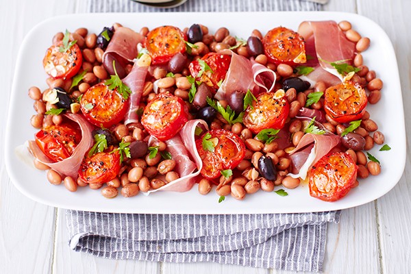 Tomato Salad Recipe with Prosciutto and Borlotti Tomato Salad Recipe with Prosciutto and Borlotti served on a long white late with a thin stripy blue and white cloth