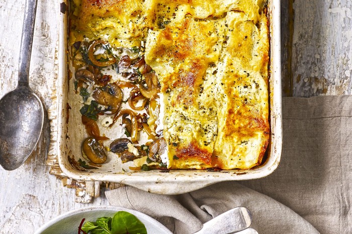 Vegetarian Spinach and Mushroom Lasagne Recipe Caramelised onion, spinach and mushroom lasagne in a large rectangle baking dish with a large serving spoon next to it