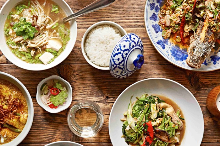 Som Saa Shoreditch Restaurant Review Overhead shot of Thai dishes on a wooden table at Somsaa