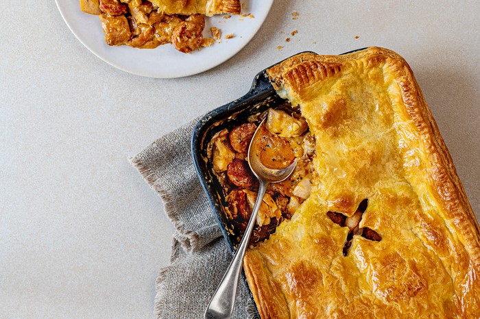 Chicken and chorizo pie A black baking dish filled with a meat pie, topped with golden pastry