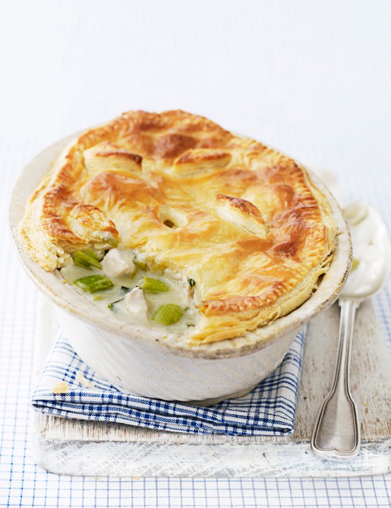 How To Make A Pie Guide A chicken and leek pie with a golden puff pastry top in a dish with a spoon next to it