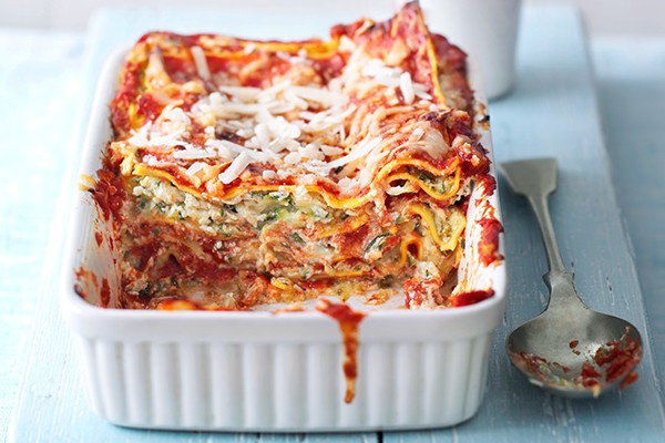 Easy Courgette Lasagne Recipe Courgette lasagne in a white rectangular baking dish with a spoon next to it