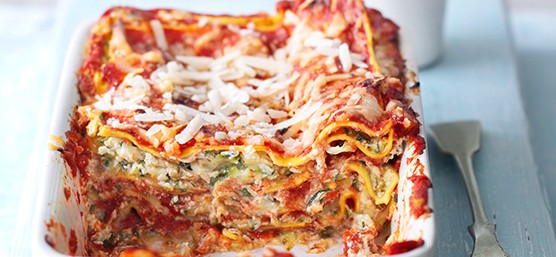 Easy Courgette Lasagne Recipe Courgette lasagne in a white rectangular baking dish with a spoon next to it