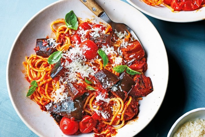 Aubergine and ’nduja spaghetti a bowl of spaghetti in a red sauce with chunks of aubergine and a wooden handled fork