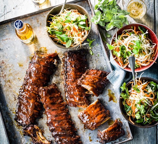 BBQ Recipes Three racks of ribs with three bowls of salad and a beer