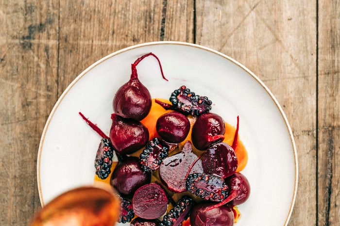 Salt-baked beetroot with macadamia and mulberry A plate of baked beetroots on a white plate