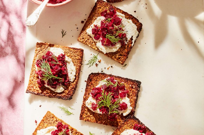 Beetroot tartare and ricotta toasts Individual toasts with ricotta and beetroot against a cream background
