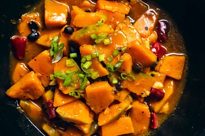 Braised-winter-squash-with-fermented-black-beans Bowl of squash and black beans topped with spring onion