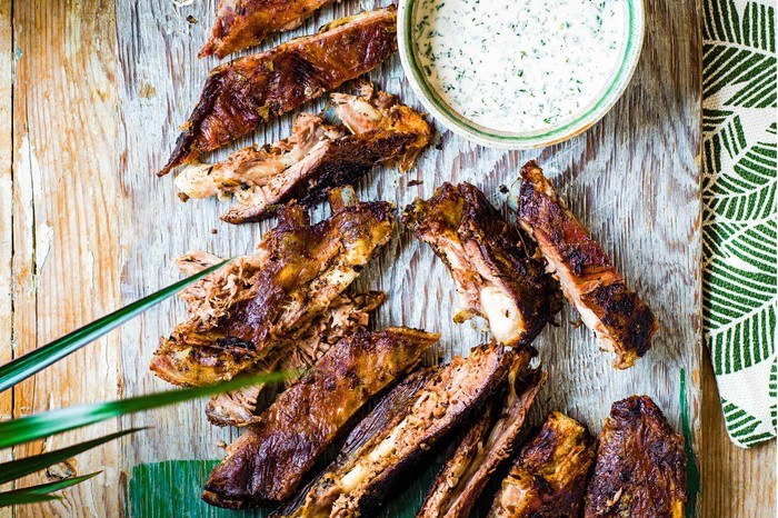 BBQ Lamb Breast Recipe with Vinegar Sauce A wooden surface topped with slices of crispy lamb breast