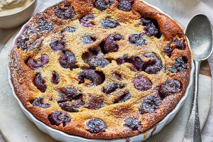 Cherry clafoutis A large cherry clafoutis in a round dish with a spoon