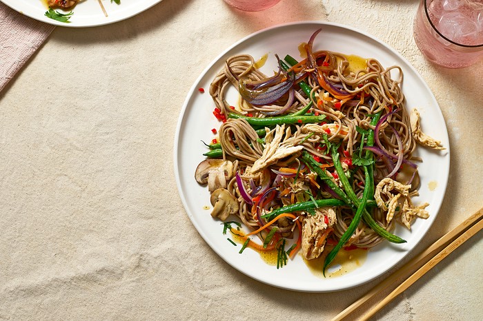 Chicken & soba noodle stir-fry Three plates of colourful stir-fry with drinks on the side
