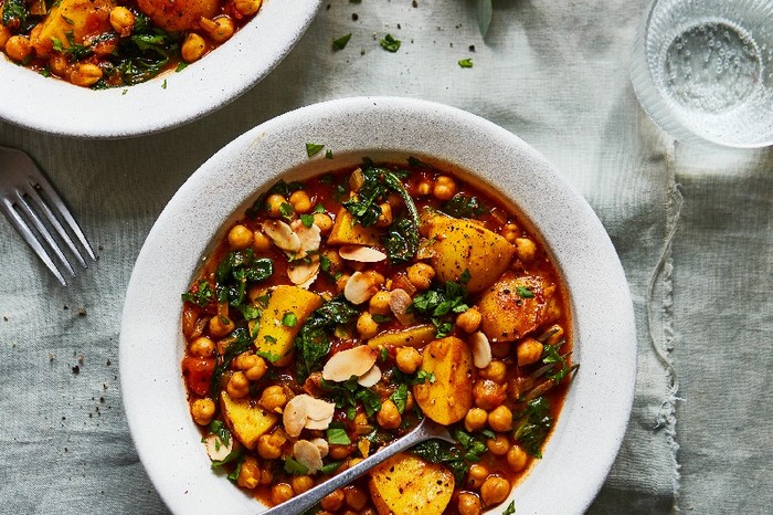 Chickpea and potato tagine Two bowls of chickpea and potato tagine on a white linen table cloth