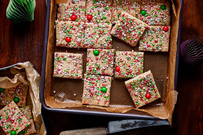 Festive gingerbread fudge cut into squares on a baking tray