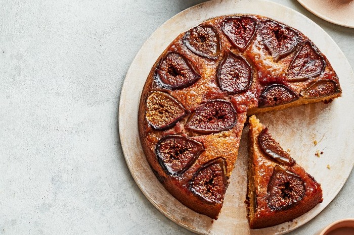 fig cake A cake topped with baked sliced figs on a beige stone plate