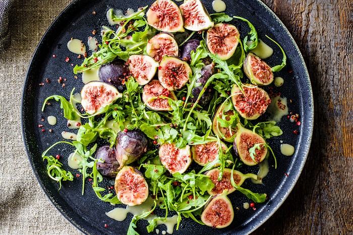 Fig salad Halved figs and salad leaves on a plate