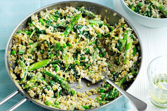Risotto with freekeh and spring greens Risotto with freekeh and spring greens in a large silver pan with serving spoon
