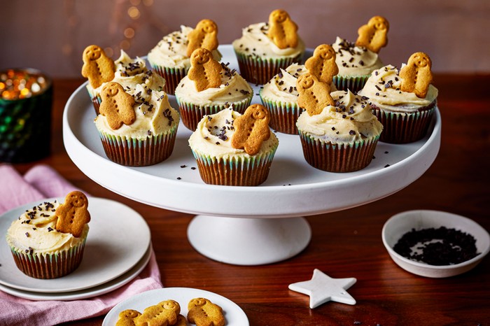 A batch of gingerbread cupcakes served on a white cake stand
