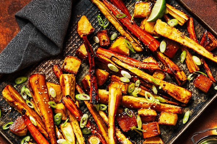 Gochujang-roasted root veg A tray of Gochujang-roasted root veg with a black kitchen cloth