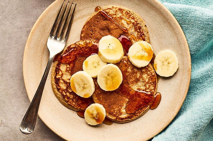 Healthy banana pancakes Plate of pancakes with syrup and bananas