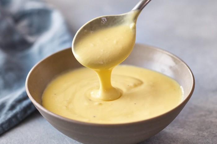 Hollandaise sauce A small bowl of hollandaise with more sauce running off a silver spoon