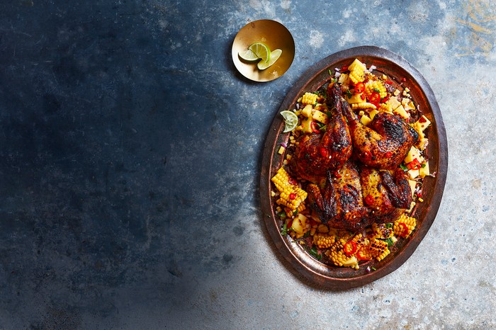 Spatchcock Chicken Recipe with Honey-Masala Glaze A whole roast chicken on a mango salad