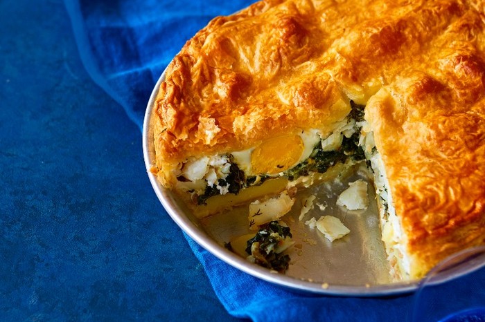 Smoked haddock pie Smoked haddock pie in a pie dish with a slice taken out, against a royal blue fabric background