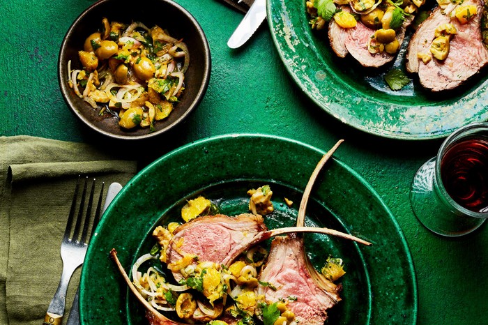 Lamb chops with green olive and orange salsa Lamb chops with an orange salsa on a green dinner plate