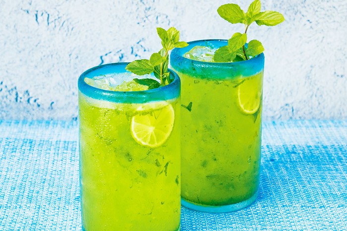 Largartija Two long green cocktails wiht lime garnish and mint