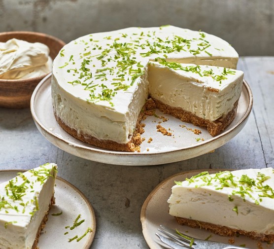 Lime cheesecake A cheesecake topped with lime zest on a cake stand with a slice taken out