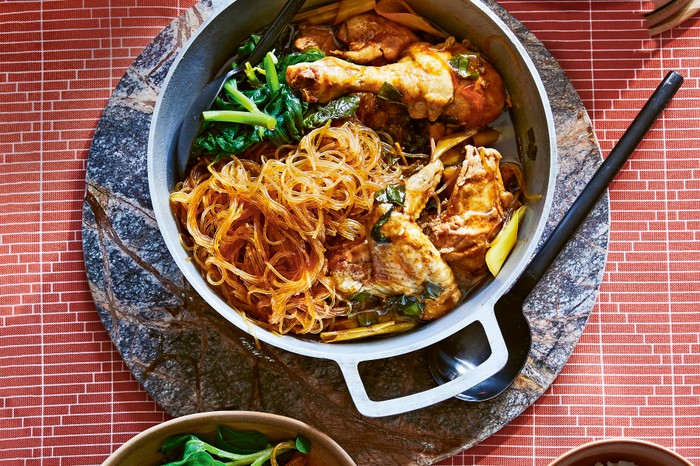 Semur chicken A metal pot filled with roast chicken, glass noodles and leafy green vegetables