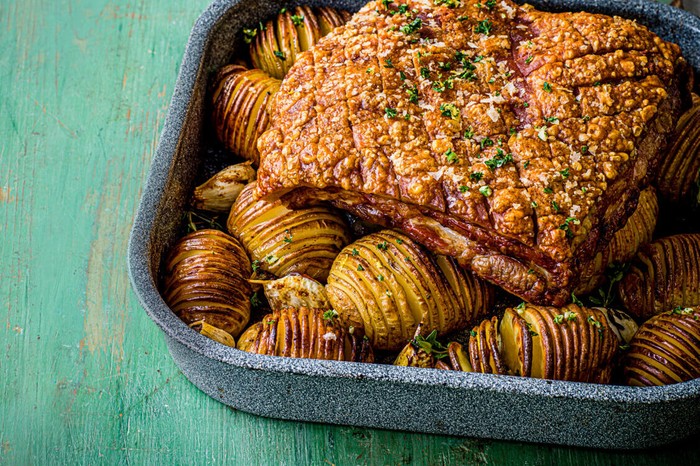 Roast pork with hasselback potatoes Roast pork with hasselback potatoes in a roasting tin