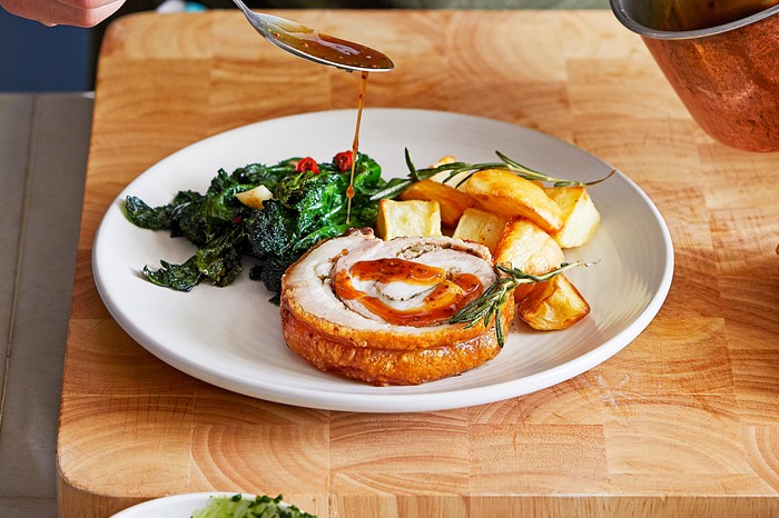 A plate of Sunday lunch with roast pork belly and potatoes
