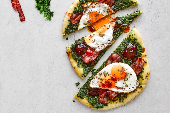 Bacon and kale pesto flatbreads A colourful flatbread with a fried egg on top