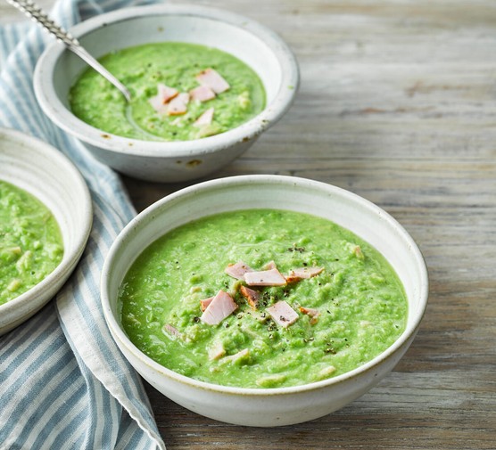 Pea and ham soup Three bowls of pea soup topped with ham slices