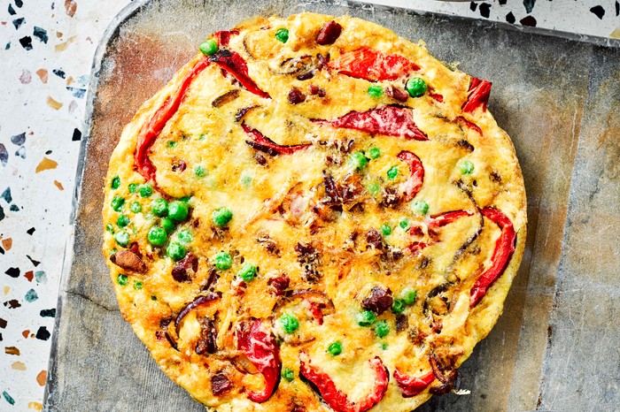 Chorizo Frittata Recipe with Red Pepper and Peas A chorizo frittata with red pepper and peas on a rustic baking tray