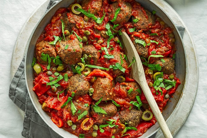 Veggie Meatballs Recipe Veggie meatballs in a large pot with a wooden spoon placed inside it
