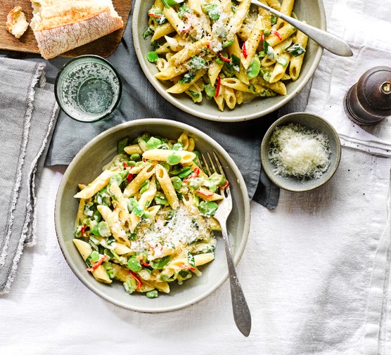 Broad bean, mint and chilli pasta A bowl of pasta with broad beans and sliced chilli on a white linen tablecloth