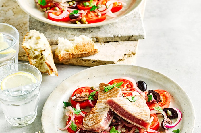 Healthy summer recipes Tuna and Tomato Salad with Olives on a White Plate