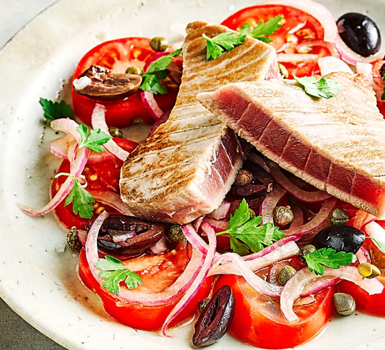 Healthy summer recipes Tuna and Tomato Salad with Olives on a White Plate