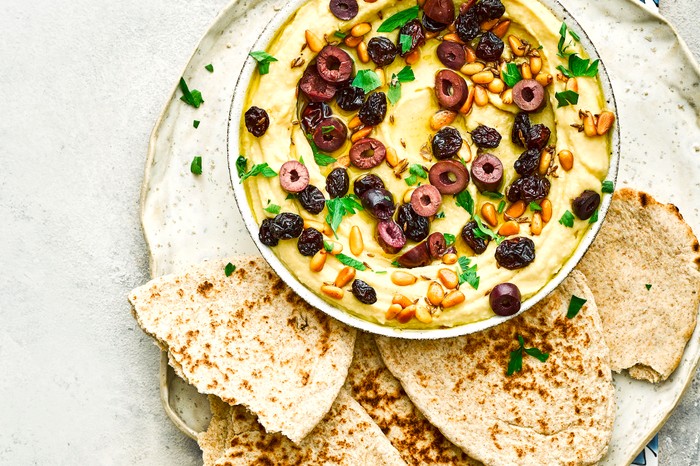 Easy Hummus Recipe Topped with Pine Nuts, Raisins and Olives Easy Hummus Recipe Topped with Pine Nuts, Raisins and Olives