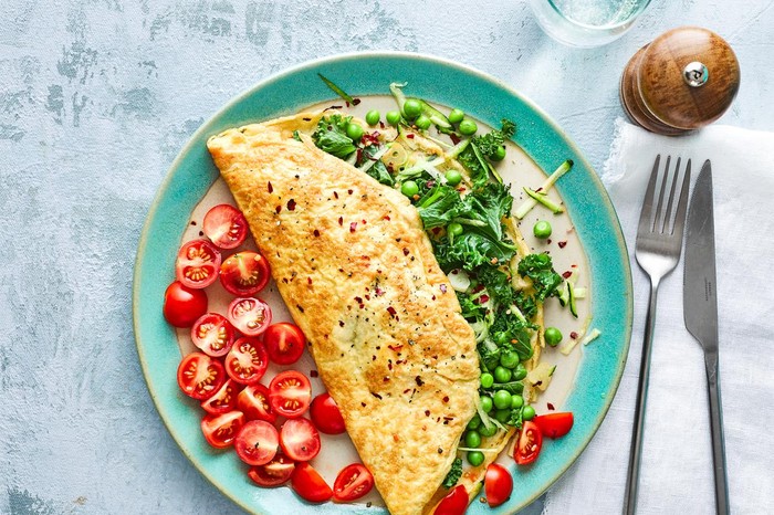 Healthy Working From Home Lunch Ideas Omelette Filled with Green Vegetables on a Plate with Tomatoes