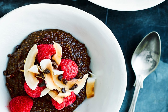 Quinoa porridge Bowl of chocolate quinoa porridge topped with raspberries and coconut shavings