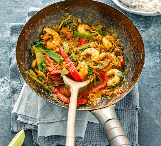 Prawn Stir Fry Recipe A silver wok is filled with prawns, chopped peppers and green vegetables