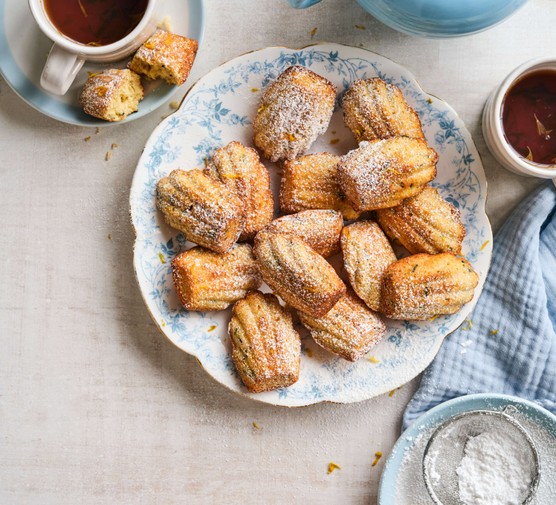 Earl grey and yogurt madeleines A plate of earl grey yoghurt madeleines next to a cup of coffee