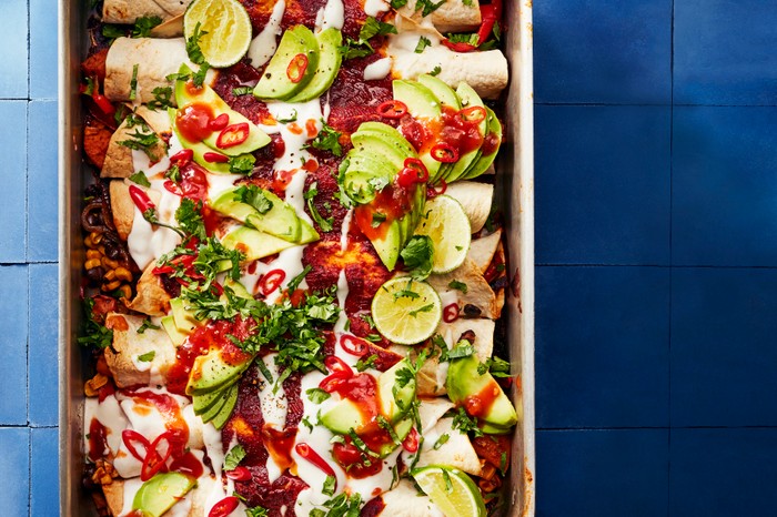 40 Dairy-Free Recipes Baking Tray Filled with Enchiladas, Hot Sauce, Coriander and Fresh Lime