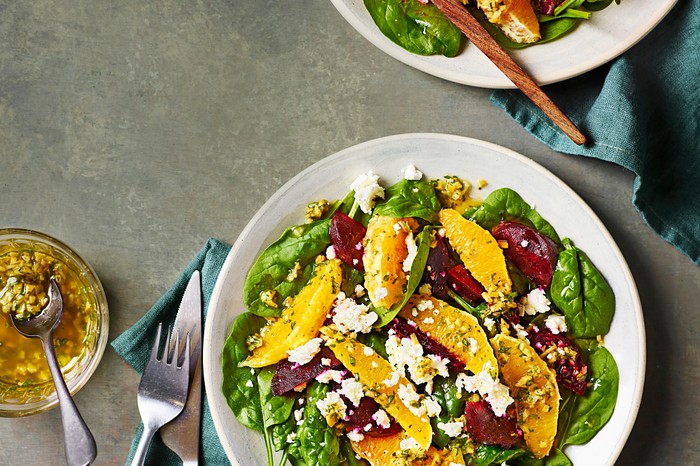 Beetroot, orange and feta salad A white bowl filled with a beetroot, orange and green leaf salad with crumbled feta on top