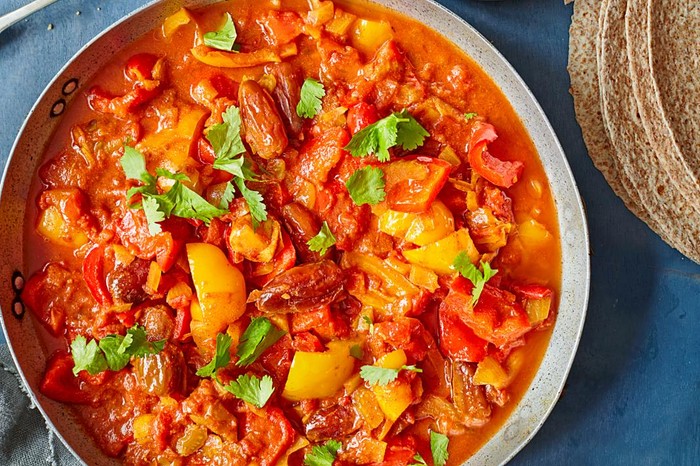 Pepper, date and harissa tagine in a serving bowl