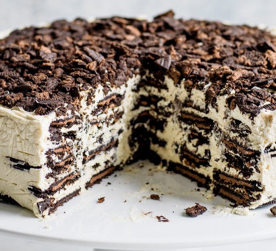 Oreo Baileys Icebox Cake Recipe Oreo Baileys fridge cake, with a large chunk taken out to reveal the layered filling