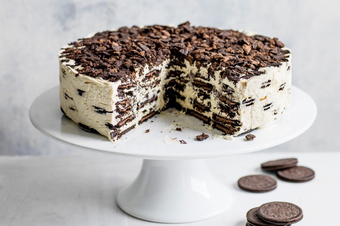 Oreo Baileys Icebox Cake Recipe Oreo Baileys fridge cake, with a large chunk taken out to reveal the layered filling