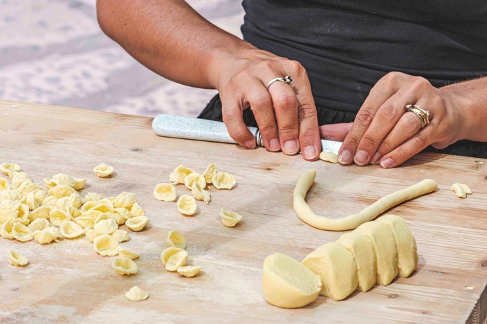 Local woman preparing in the street of Bari old town orecchiette or orecchietta Local woman preparing in the street of Bari old town orecchiette or orecchietta, made with durum wheat and water, handmade pasta typical of Puglia or Apulia, a region of Southern Italy, close up